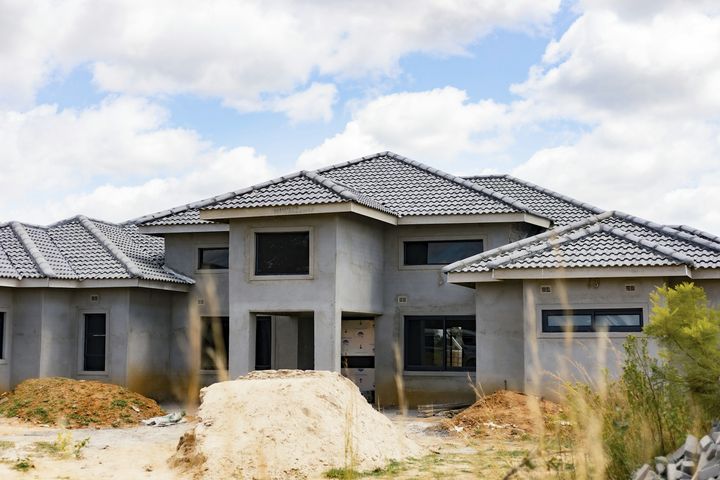 A block and stucco house with a tile roof at the finishing stage of construction