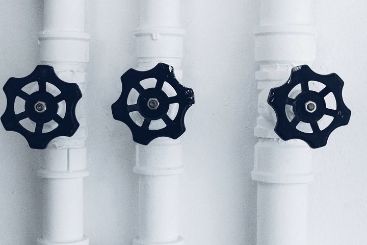 Three shut-off valves on white water pipes