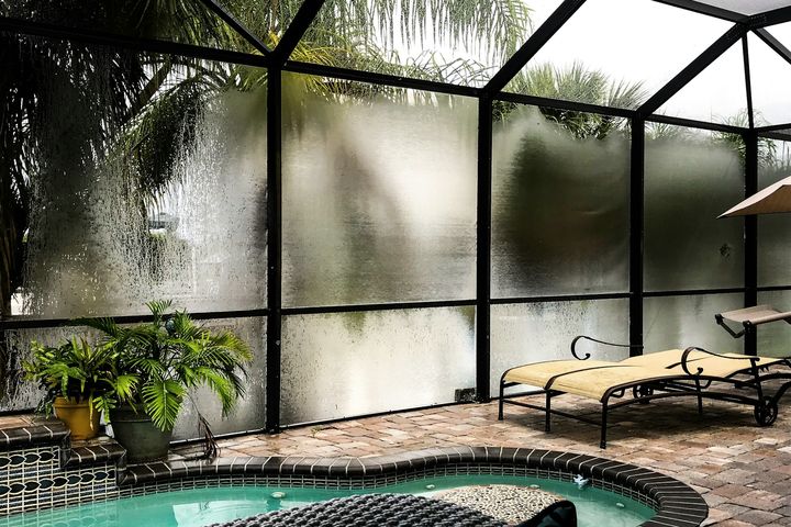 A screened pool enclosure with a spa in Port Charlotte, Florida